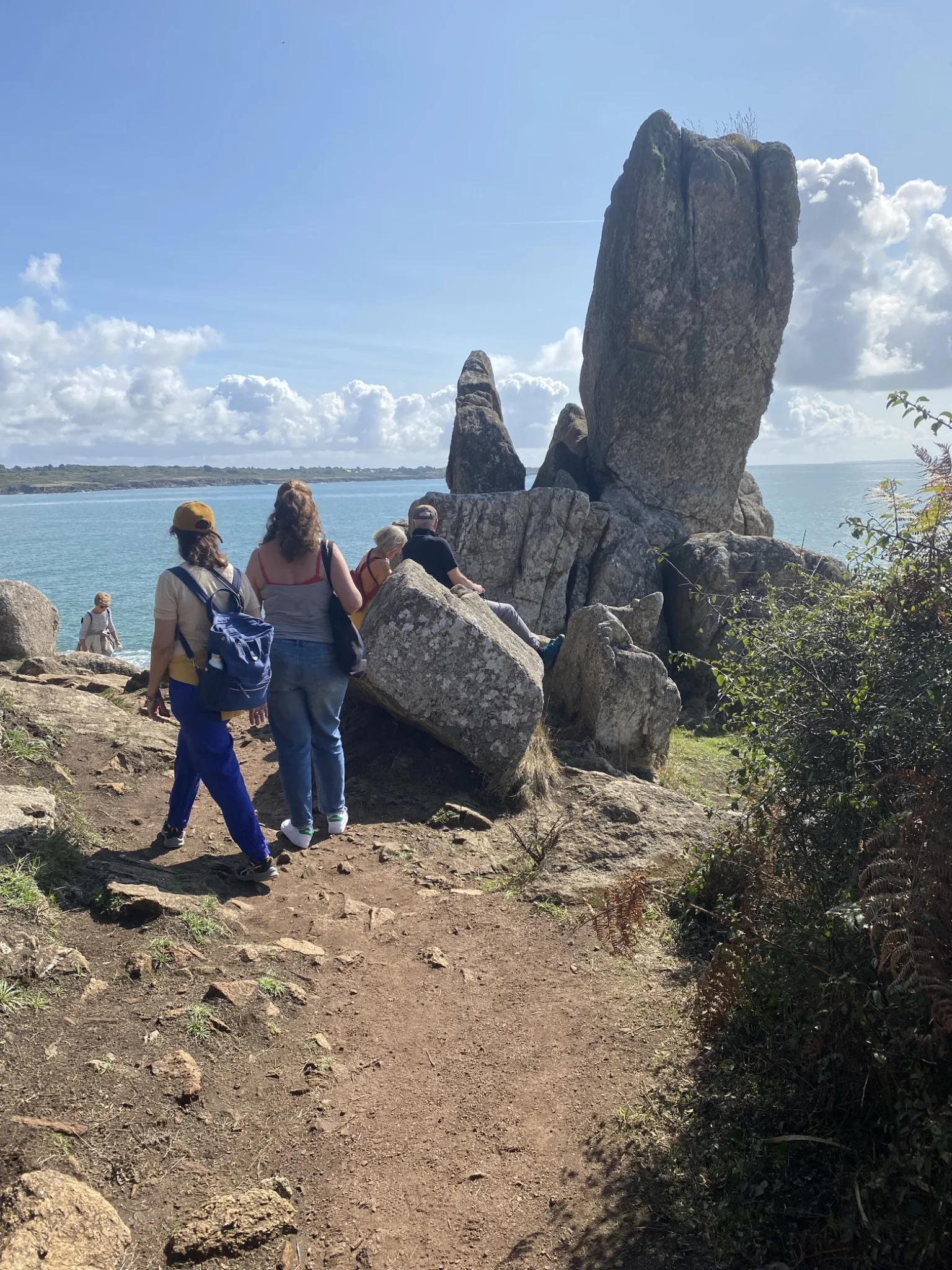 Une groupe se promène en bord de mer sur le GR34 en Bretagne. Entre ciel et mer… bleus.