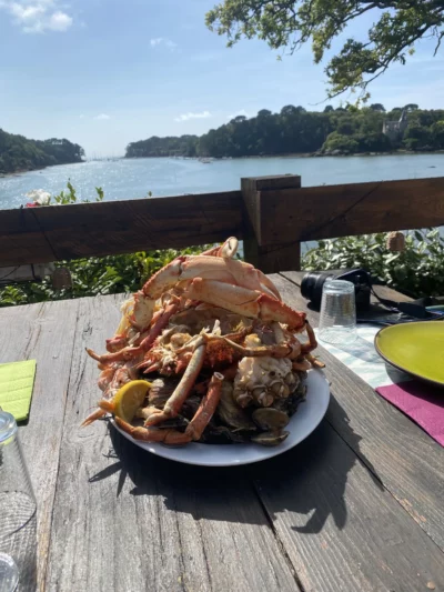 gros plan sur une copieuse assiette de fruit de mer et de pattes d'araignée de mer sur fond bleu du ciel et de la mer.