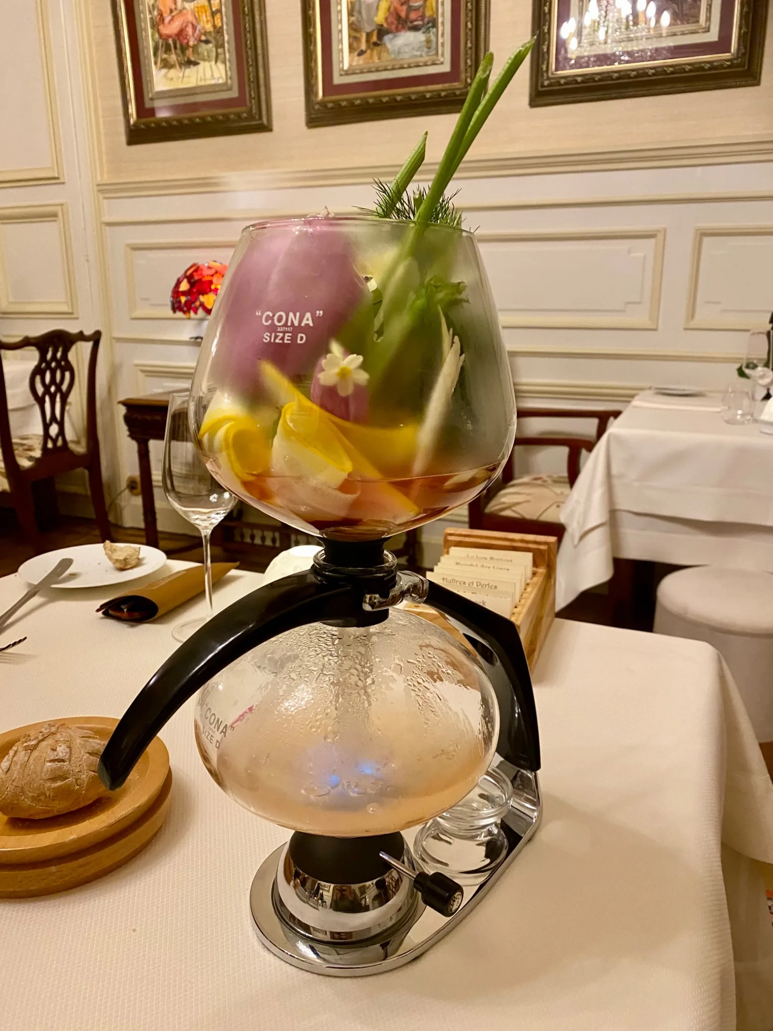 cafetière Cona avec un mélange de légumes et des plantes et de fleurs.